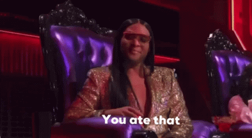 A Woman In A Gold Jacket Is Sitting In A Purple Chair And Talking . GIF