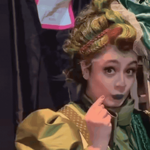 a woman in a green and yellow costume has a braided headband on her head