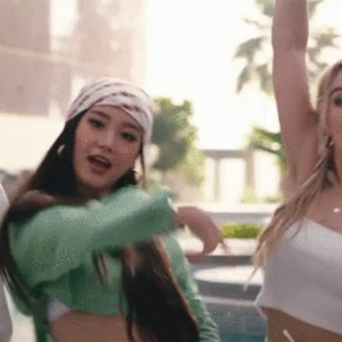 A Woman In A Green Crop Top And A White Top Is Dancing . GIF