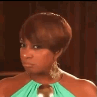 a woman in a green dress and earrings is making a face .