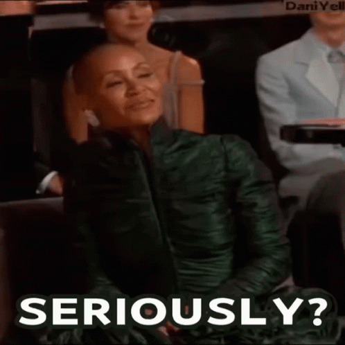 A Woman In A Green Dress Is Sitting In A Audience And Says Seriously . GIF