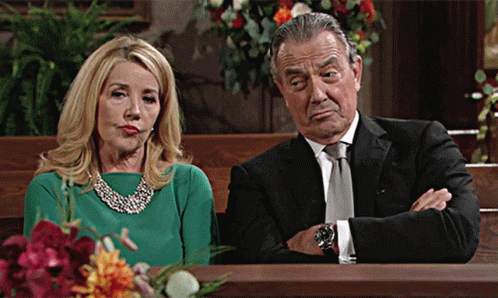 A Woman In A Green Dress Sits Next To A Man In A Suit GIF