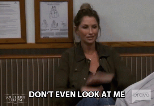A Woman In A Green Jacket Is Sitting In A Chair And Says " Don 'T Even Look At Me " . GIF