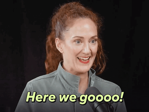 A Woman In A Green Jacket Is Smiling And Says Here We Goooo GIF
