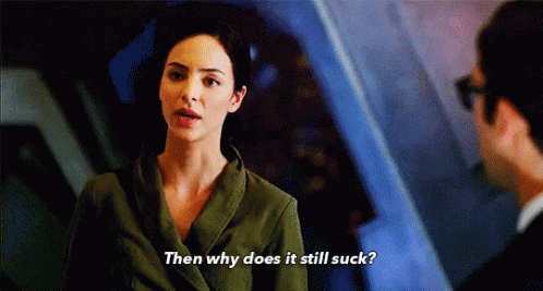 A Woman In A Green Jacket Is Talking To A Man And Says Then Why Does It Still Suck GIF