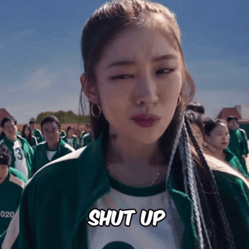 A Woman In A Green Jacket Says Shut Up In Front Of A Crowd GIF