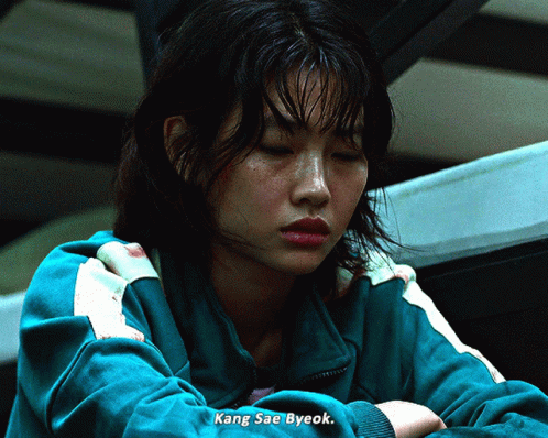 A Woman In A Green Jacket With Kang Sae Byeok Written On The Bottom GIF