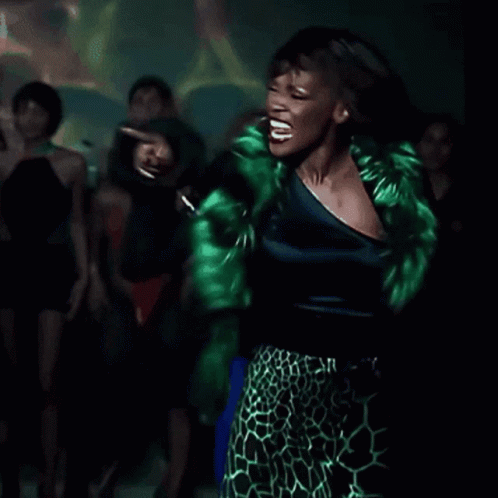 Woman In Green Leopard Print Skirt Dancing In Dark Room GIF