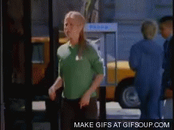 A Woman In A Green Shirt Is Dancing In Front Of A Yellow Taxi GIF