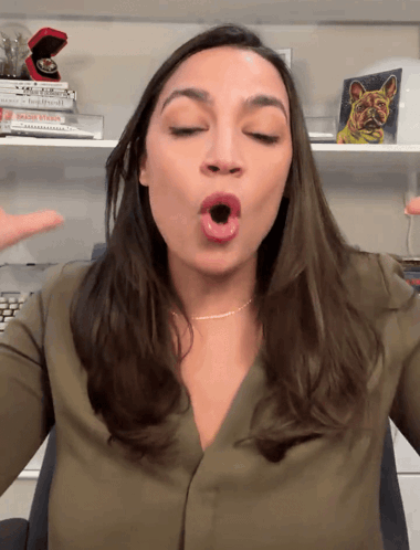A Woman In A Green Shirt Is Making A Face With Her Mouth Open GIF