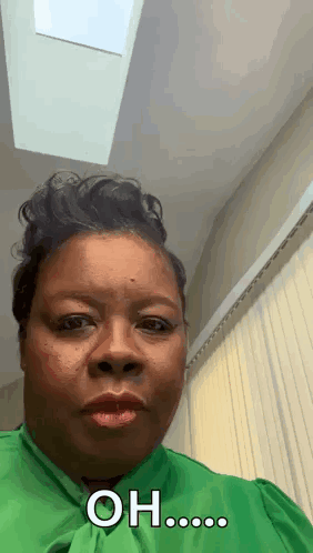A Woman In A Green Shirt Is Making A Funny Face And Saying Oh ... GIF
