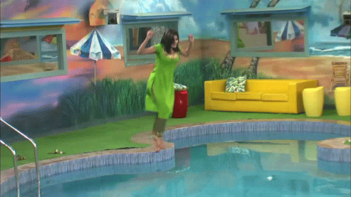A Woman In A Green Shirt Is Swimming In A Pool GIF