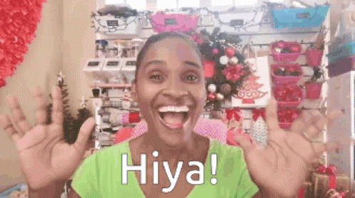 A Woman In A Green Shirt Says Hiya With Her Hands Up GIF