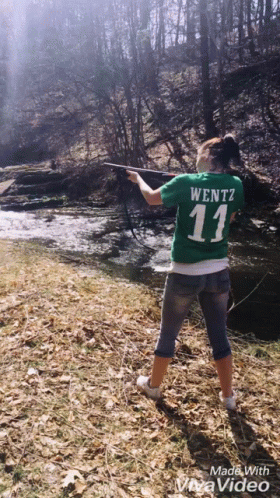 A Woman In A Green Shirt With The Number 11 On It Is Fishing GIF