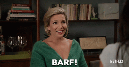 A Woman In A Green Sweater Says Barf While Talking To Another Woman GIF