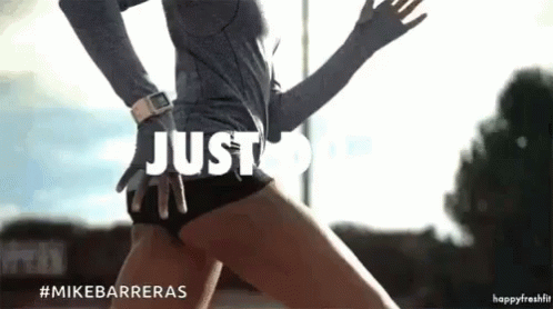 A Woman In A Grey Shirt And Black Shorts Is Running With The Words Just Do It Above Her GIF