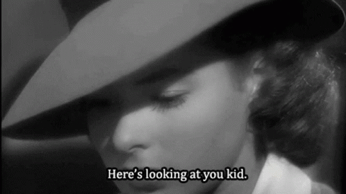 a woman in a hat says here 's looking at you kid .