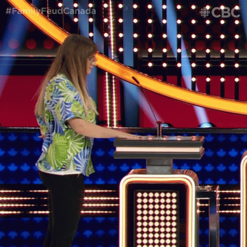 A Woman In A Hawaiian Shirt Is Playing A Game On A Television Show Called Family Feud Canada GIF