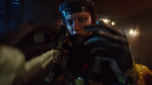 A Woman In A Helmet Is Holding A Rifle In Her Hand GIF