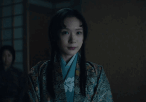 a woman in a kimono looks at the camera
