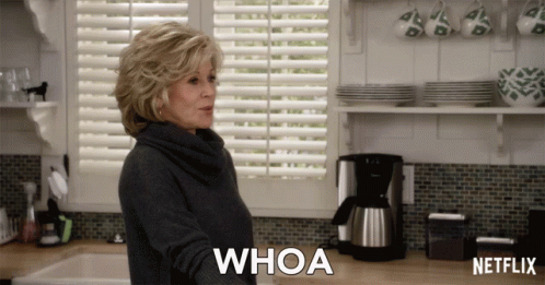 A Woman In A Kitchen Says Whoa In Front Of A Netflix Coffee Maker GIF