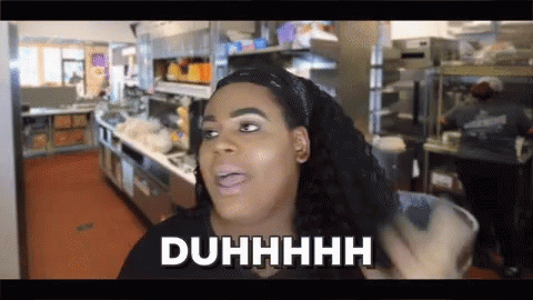 A Woman In A Kitchen With The Word Duhhhh Written On Her Face GIF