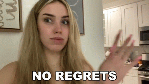 A Woman In A Kitchen With The Words No Regrets On Her Face GIF