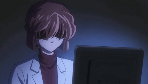 A Woman In A Lab Coat Is Looking At A Monitor GIF