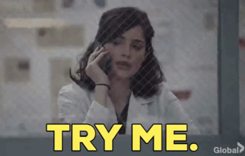 a woman in a lab coat is talking on a cell phone and the words try me are displayed .