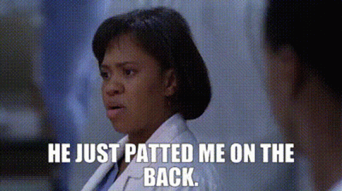 A Woman In A Lab Coat Is Talking To A Man In A Hospital Room And Says He Just Patted Me On The Back . GIF