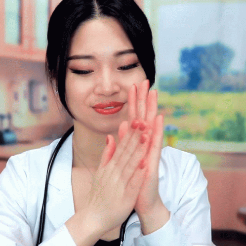 A Woman In A Lab Coat With A Stethoscope Around Her Neck Applauds GIF