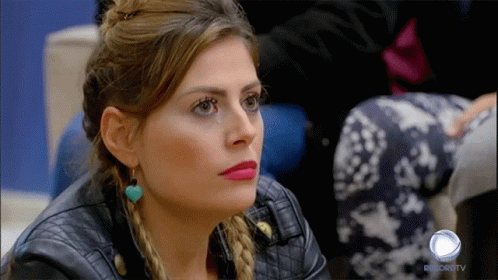 A Woman In A Leather Jacket Is Sitting In Front Of A Record Tv Logo GIF