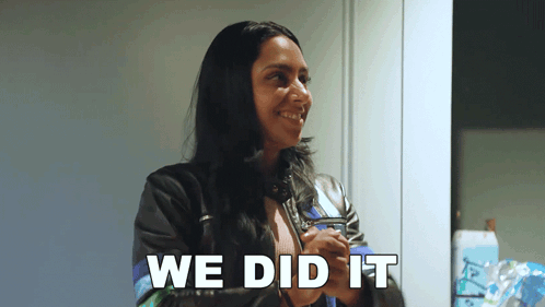 A Woman In A Leather Jacket Is Smiling With The Words We Did It Behind Her GIF