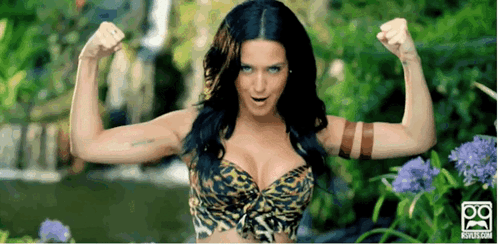 A Woman In A Leopard Print Bra Is Flexing Her Muscles GIF