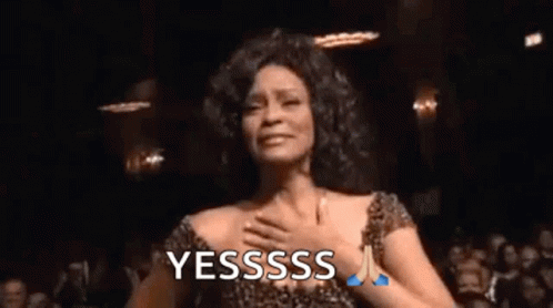 a woman in a leopard print dress is dancing in front of a crowd and says yesssss .