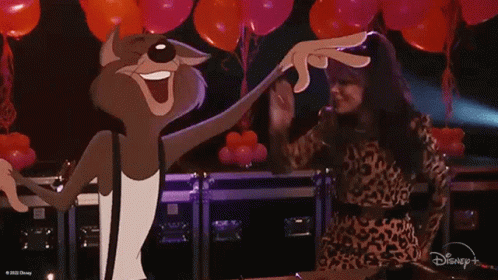 A Woman In A Leopard Print Dress Is Dancing Next To A Cartoon Cat . GIF