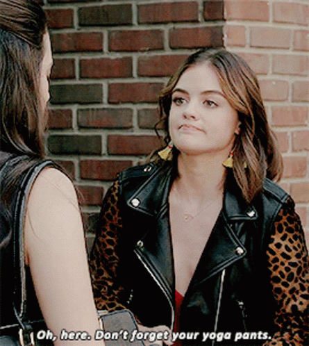 A Woman In A Leopard Print Jacket Is Talking To Another Woman In Front Of A Brick Wall GIF