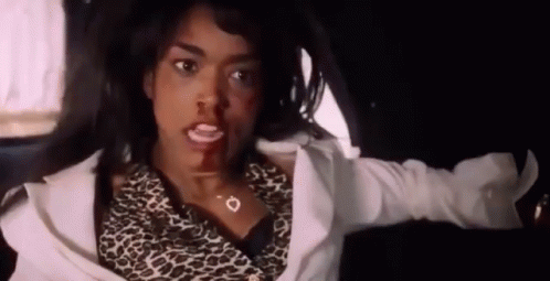 A Woman In A Leopard Print Shirt Is Sitting In A Car With Her Shirt Off . GIF