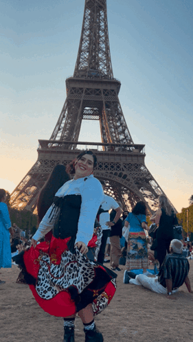 A Woman In A Leopard Print Skirt Is Posing In Front Of The Eiffel Tower GIF