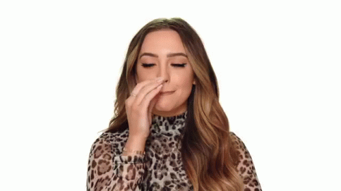 A Woman In A Leopard Print Top Is Making An Ok Sign With Her Hand . GIF