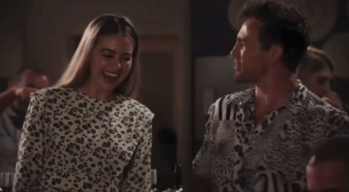 A Woman In A Leopard Print Top Smiles Next To A Man GIF