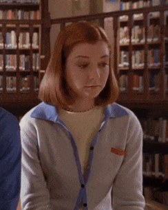 A Woman In A Library With The Words A-Ha Written On Her Face GIF