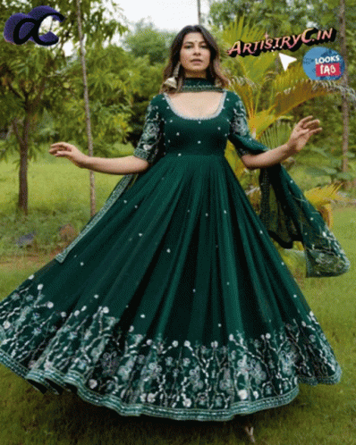 A Woman In A Long Green Dress With Artistry In Written On The Bottom Right GIF