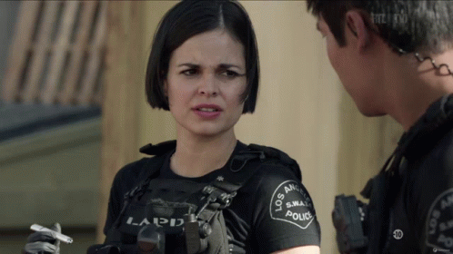 A Woman In A Los Angeles Police Uniform Holds A Cigarette In Her Hand GIF