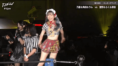 a woman in a maid outfit is dancing in front of a referee and a sign that says tjpw on it