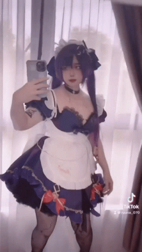 A Woman In A Maid Outfit Is Taking A Selfie GIF