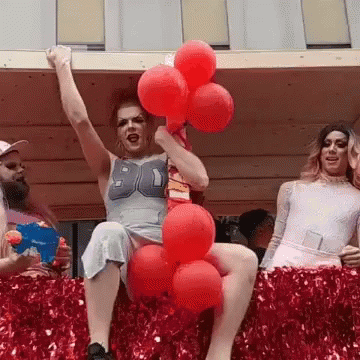 A Woman In A Number 90 Shirt Is Holding Red Balloons In Her Hand GIF
