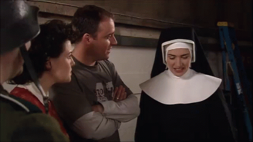 A Woman In A Nun Costume Talks To A Man Wearing A Shirt That Says 32 GIF