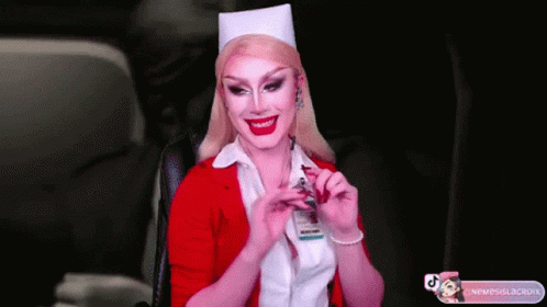 A Woman In A Nurse Costume Is Smiling And Holding A Badge GIF