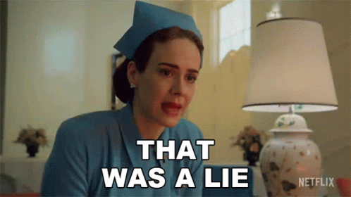 A Woman In A Nurse 'S Uniform Says That Was A Lie In Front Of A Lamp . GIF